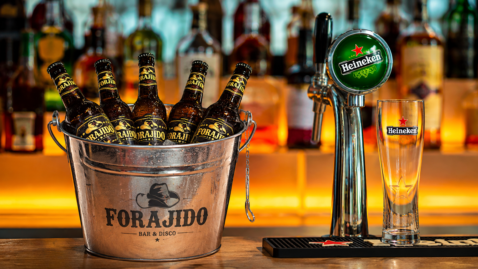 Cubo con cinco cervezas Forajido y cerveza de tiro en la barra